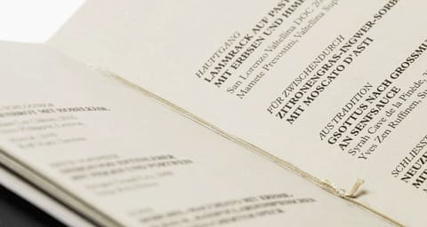Close-up of printed matter on cream paper with diagonal lines of type