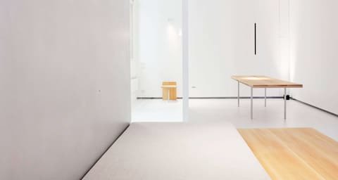 Bright, minimalist room with a wooden table and bench