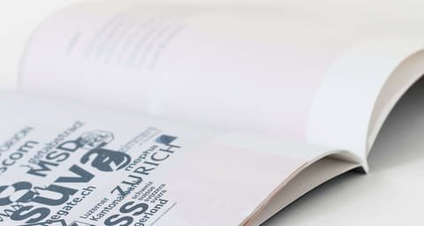 Close-up of an open brochure with a typographic collage of company names