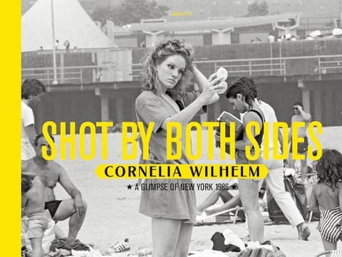 Book cover Shot by Both Sides by Cornelia Wilhelm with yellow title on a black and white beach photo