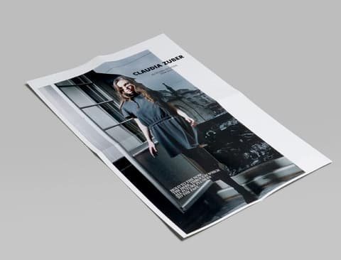 Unfolded Claudia Zuber lookbook sheet with a large photo of a model at a window front