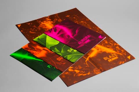 Fanned-out Dayglo posters by Fischer Papier on fluorescent orange, pink and green paper
