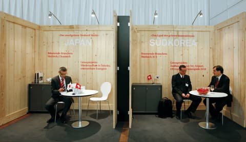 Switzerland Global Enterprise exhibition stand with wooden consultation booths for Japan and South Korea