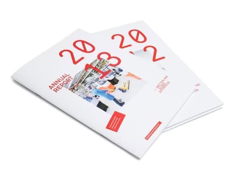 Two Switzerland Global Enterprise annual reports with large red year numerals on the covers