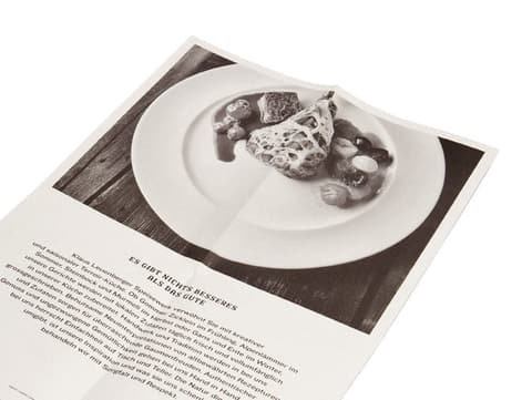 Unfolded leaflet from Klaus Leuenberger Speisewerk with a large black-and-white photo of a dish