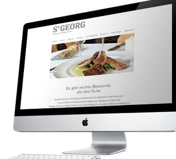 St. Georg restaurant website with a food photograph on a desktop screen