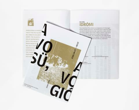 Roger Stüssi flyers with gold print and large black type lying on an open brochure